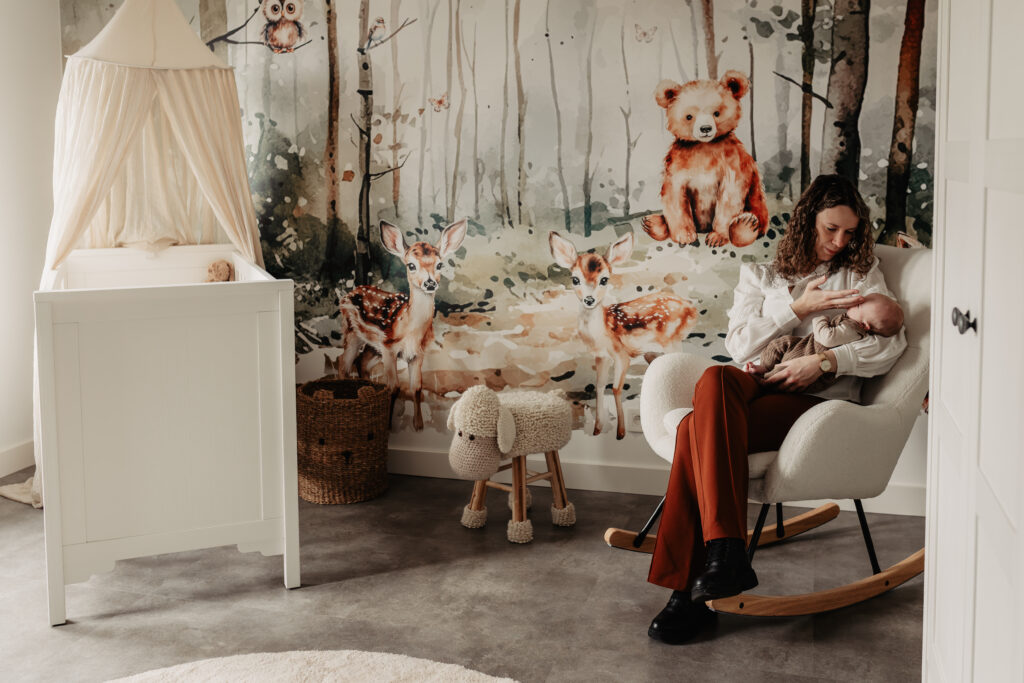 Sfeervolle babykamer met witte wieg en dierlijk behang, vastgelegd tijdens een newbornshoot thuis.