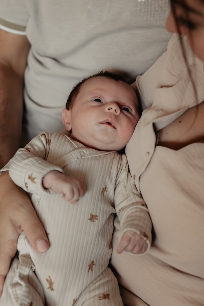knuffelende ouders met hun pasgeboren kindje – leeftijd newborn fotoshoot