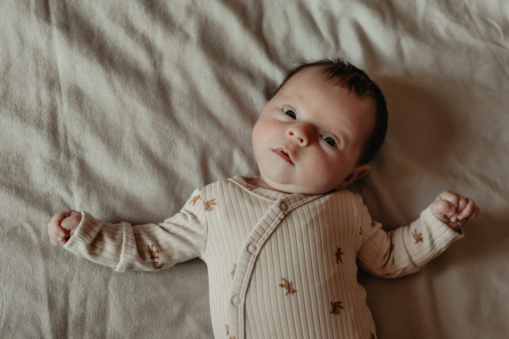 ouders met pasgeboren baby tijdens newbornshoot thuis