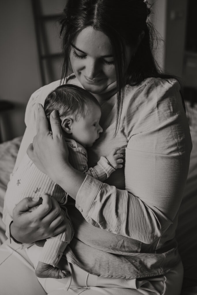 mama met pasgeboren baby tijdens newbornshoot thuis – beste leeftijd newbornshoot