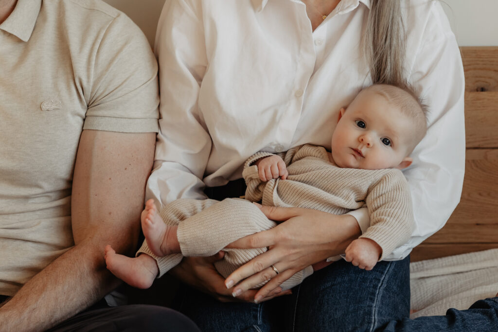 Ouders met baby op bed tijdens newbornshoot in Baarle-Nassau
