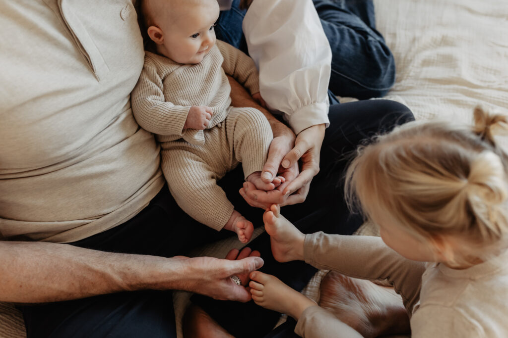 Ouders met baby op bed tijdens newbornshoot in Baarle-Nassau