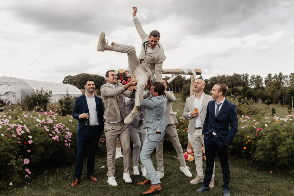 Groepsfoto van het bruidspaar met vrienden op de trouwdag